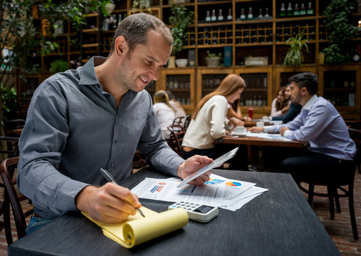 Male restaurant business owner managing his employees' payroll and other benefits - reasons to outsource restaurant payroll service.